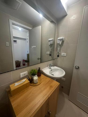 a bathroom with a sink and a mirror at Sky26 Stays by Paula & Hudson in Pampang