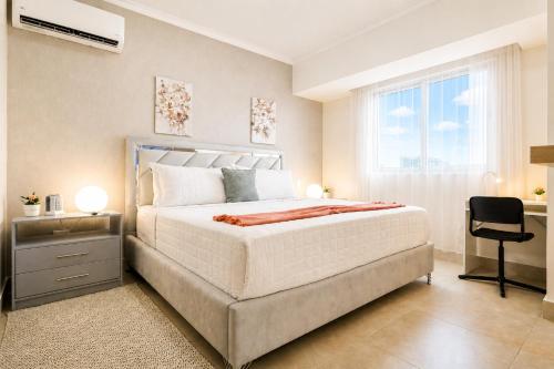 a bedroom with a bed and a desk and a window at Comfy City Center 1BR Condo in Los Prados