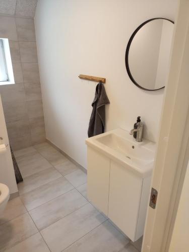a bathroom with a white sink and a mirror at Sønderhedens B&B in Vrå