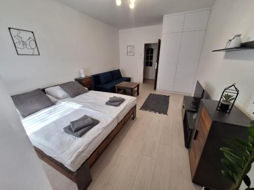 a bedroom with a large bed and a living room at ApartmanONE in Hlohovec