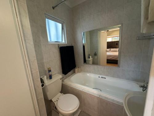 a bathroom with a toilet and a tub and a sink at Cute Pool Side Apartment in Monte Vista