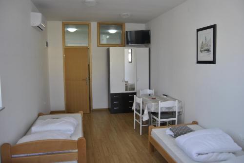 mały pokój z 2 łóżkami i stołem w obiekcie Rooms Prišlin w mieście Bjelovar