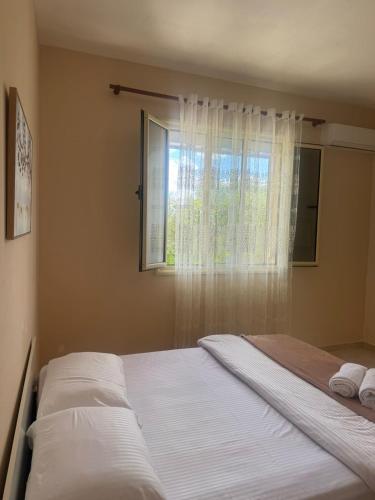 a bed in a bedroom with a window and towels at Luna Stay in Vlorë