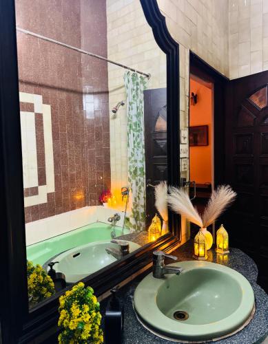 a bathroom with a green tub and a sink at The Regalis Villa in Lucknow