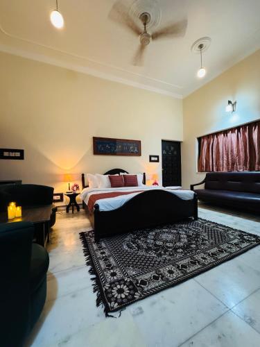 a bedroom with a bed and a couch and a rug at The Regalis Villa in Lucknow