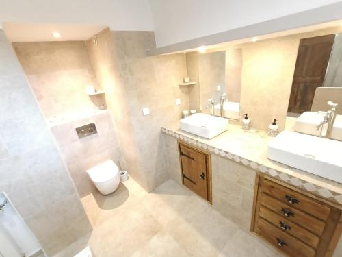 a bathroom with two sinks and a toilet at Mas La Gentille ,,, à la campagne , beautiful outdoor , swimming pool , pool house , Nice green Garden , BBQ ,,, only for you , pour passer un séjour inoubliable in Pernes-les-Fontaines