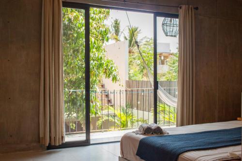 a bedroom with a bed and a large window at Casa Sol Sombra in Brisas de Zicatela