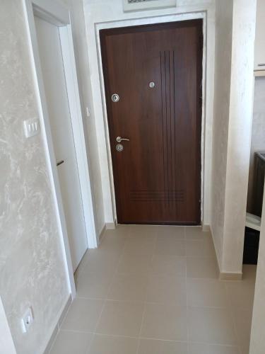 a hallway with a wooden door and a tile floor at Vendetta Montenegro in Risan