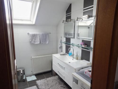 a white bathroom with a sink and a mirror at Dreiflüsse Appartement - Traumgarten mit Grill und Pavillon, WLAN, Küche und Parkplatz in Salzweg