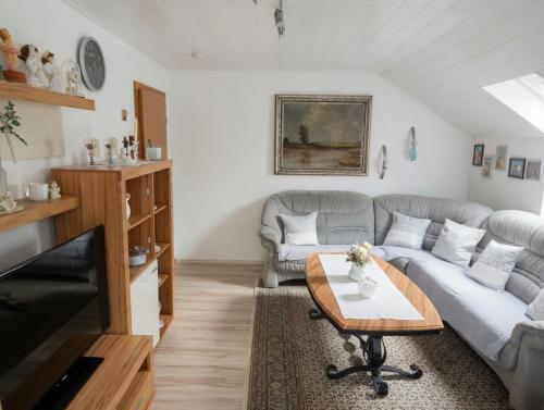 a living room with a couch and a table at Dreiflüsse Appartement - Traumgarten mit Grill und Pavillon, WLAN, Küche und Parkplatz in Salzweg