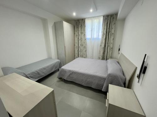 a small bedroom with two beds and a window at Casa Vacanze Tortora in Tortora