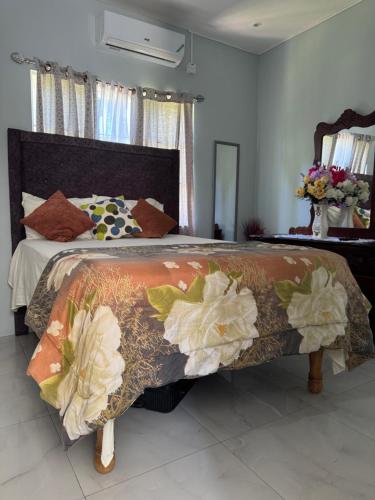 a bedroom with a large bed with flowers on it at Faith moves mountains in Ocho Rios