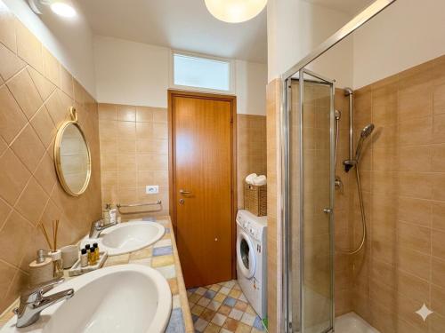 a bathroom with a sink and a shower and a washing machine at La Specola di Galileo con ampia vasca idromassaggio in Acquasparta