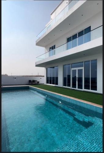 a swimming pool in front of a building at شاليهات الجوهرة in Fins