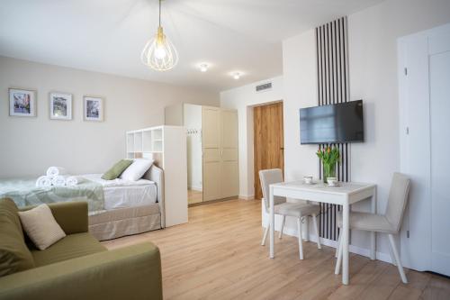 a bedroom with a bed and a table and a television at Apartament Daisy II Pszczyna Centrum in Pszczyna