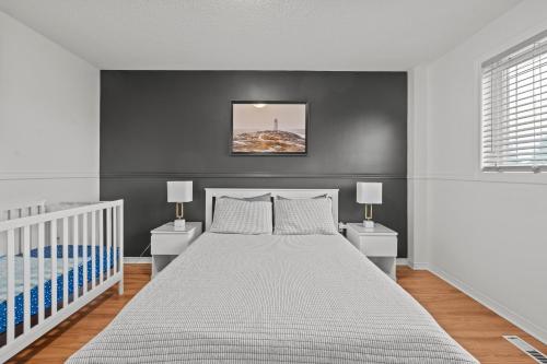 a bedroom with a white bed and two night stands at 3 Bedroom suite Upper Level of House 8 guests in Barrie