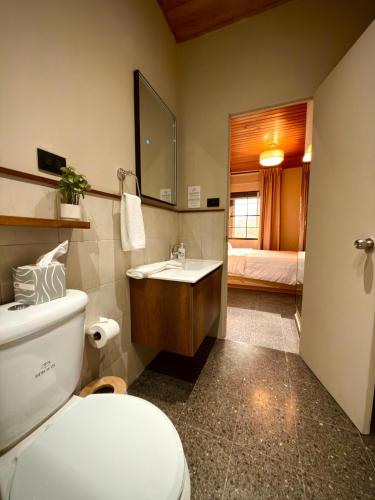 a bathroom with a toilet and a sink and a bed at Cardedeu Suites in San Salvador