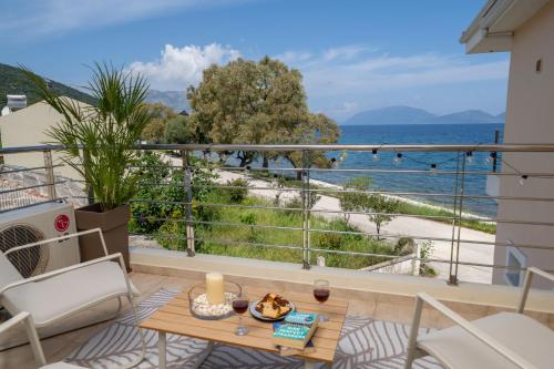 a balcony with a table and a view of the ocean at Aura Seaside Apartment in Karavomylos