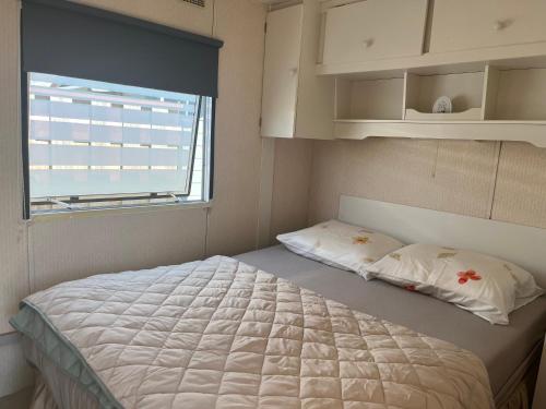 a small bedroom with a bed and a window at het straatje in Scherpenisse