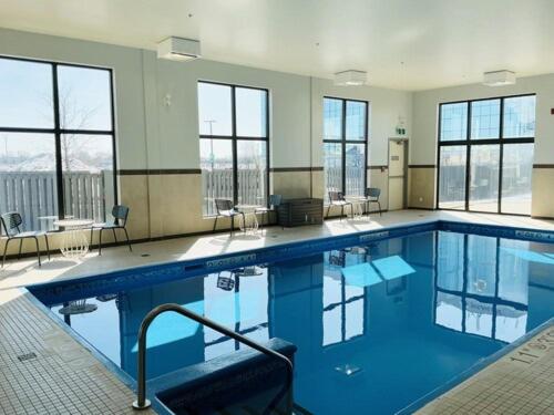 a large swimming pool in a building with windows at Spark by Hilton Montreal Brossard in Brossard