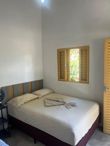 a bed in a bedroom with a window at Cantinho da Naná in Cavalcante