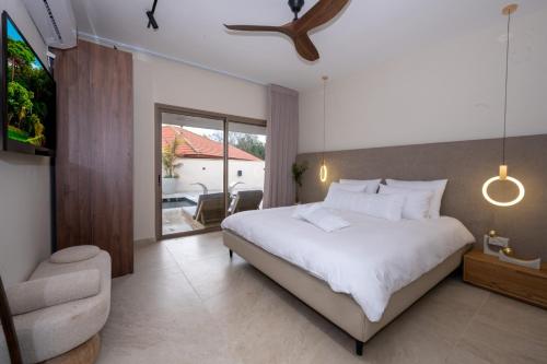 a bedroom with a large bed and a balcony at אלאיה סוויטות יוקרה in Shomera