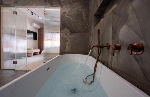 a bath tub with a water faucet in a bathroom at אלאיה סוויטות יוקרה in Shomera