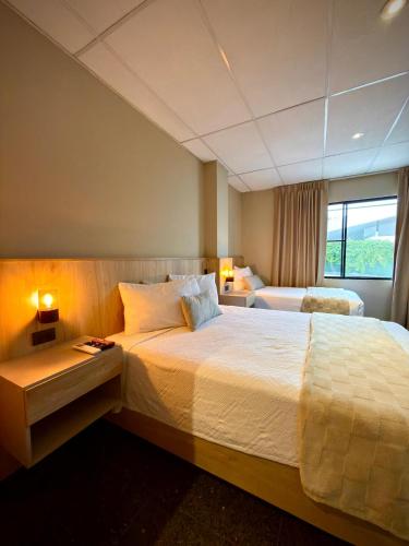 a hotel room with a large bed and a window at Cardedeu Suites in San Salvador