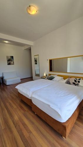 a large white bed in a bedroom with wooden floors at Villa Konalic in Mokošica