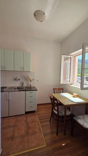 a kitchen with a table and a sink and a table at Villa Konalic in Mokošica