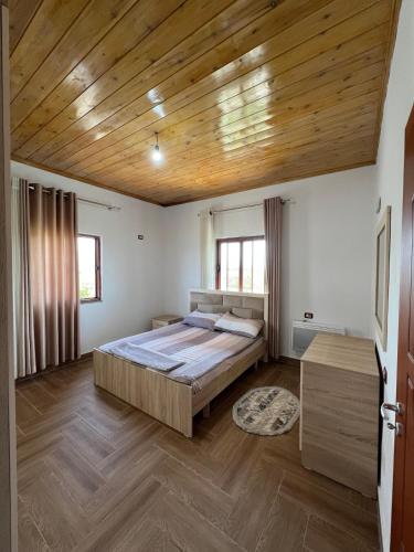 a bedroom with a bed and a wooden ceiling at Bert-House close to the sea in Lezhë