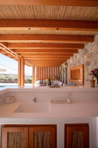 a kitchen with a white sink and a stone wall at Mystic Harmony in Mikonos