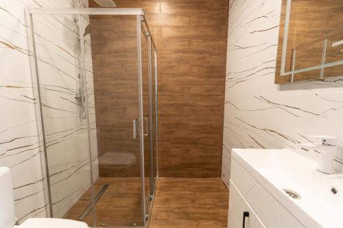 a shower with a glass door in a bathroom at Galaktyka Hotel in Stantsiya Biskovitse