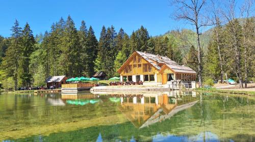 a log cabin sitting on top of a lake at Gostišče Jezersko in Zgornje Jezersko