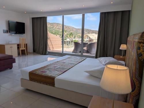 a bedroom with a bed and a large window at Hotel Strela Tarrafal in Tarrafal