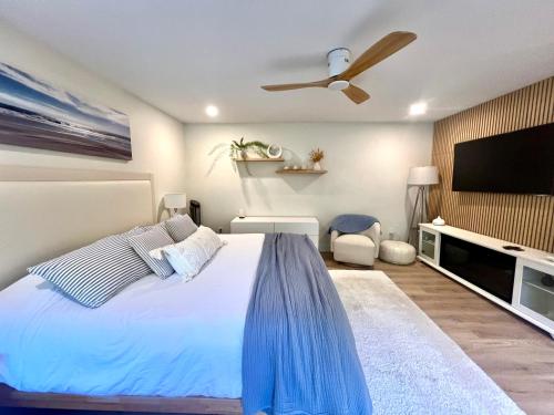 a bedroom with a bed and a flat screen tv at Low Tide Suite - Modern, Oceanside Suite with King Bed, Resort Pool & Hot Tub in Nanoose Bay