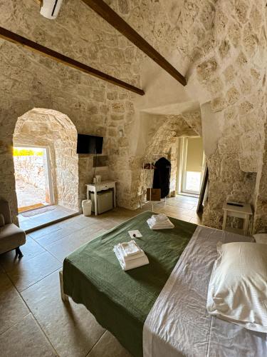 a bedroom with a large bed in a stone building at Trullo Moi in Ostuni