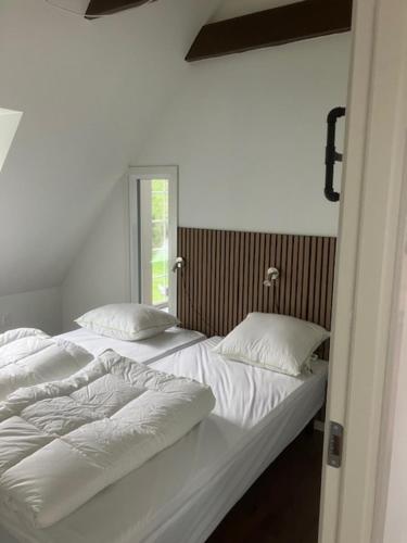 a bedroom with two beds with white sheets and pillows at Penthouse deluxe in Hobro