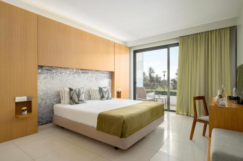 a hotel room with a bed and a table and a desk at Agua Hotels Riverside in Ferragudo