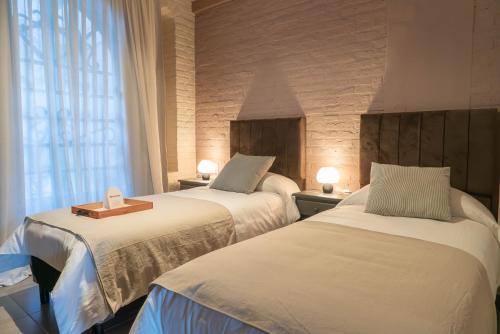 a hotel room with two beds and a window at Trento Hotel Boutique in San Salvador de Jujuy