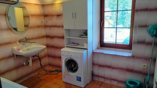 a bathroom with a washing machine and a sink at Apartmán Andels I in Rakovník