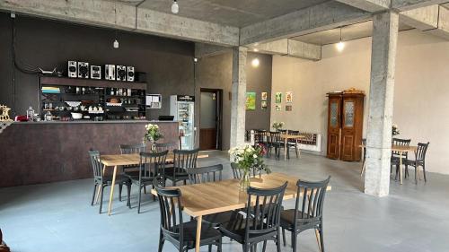 a restaurant with wooden tables and chairs and a kitchen at Park Side Hotel Tsalka in Tsalka