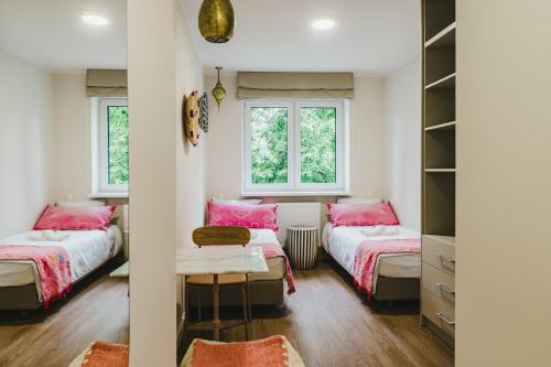 a bedroom with two beds and two windows at Villa boZEN w Juracie in Jurata