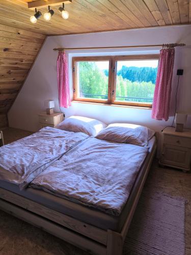 a bedroom with a large bed with a window at Chata Na Kačce in Borowa