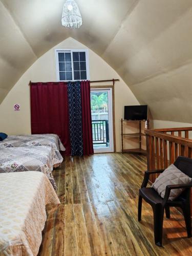 a attic bedroom with two beds and a window at Cabaña Bungalow in Tela