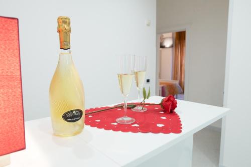 a bottle of champagne and two glasses on a table at Hibiscus in Taranto