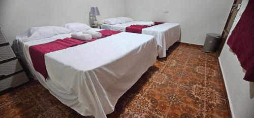two beds with white sheets in a room at María House in San Miguel
