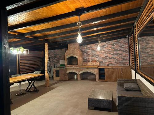 a large living room with a brick fireplace at Cabin&Villa Property in Târgu Ocna