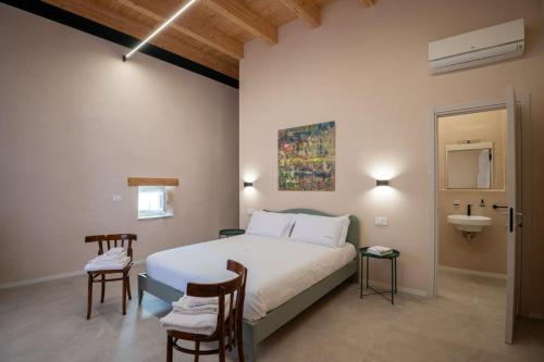a bedroom with a white bed and a sink and a sink at Borgo Puglia in Bisceglie