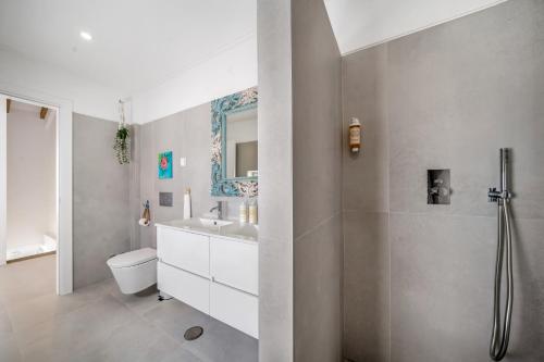 a bathroom with a sink toilet and a mirror at The Blue House - Mediterranean Loft in Faro